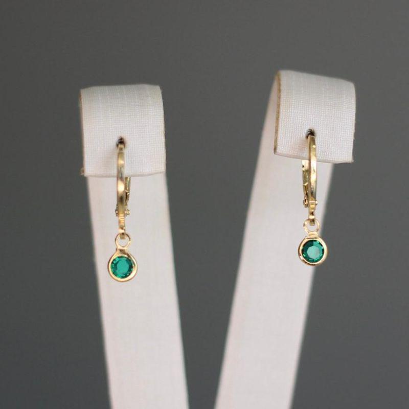 O brinco infantil argolinha articulada com zircônia verde